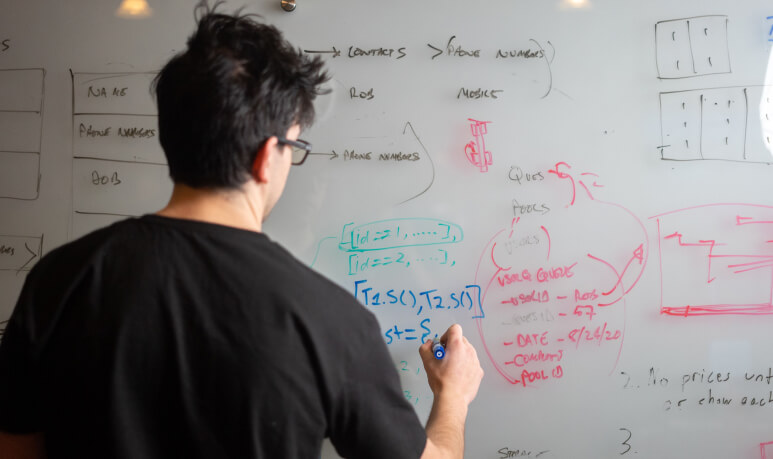 Developer working through architecture on a whiteboard